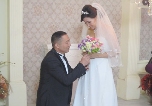 婚纱拍摄现场熊先生为妻子戴上戒指